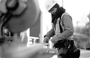 a Green Hammer employee on a job site taking a measurement with a tape measure
