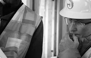Green Hammer employee with a hard hard inspecting a document
