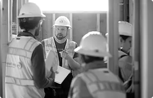 Green Hammer employees on a job site having a discussion together
