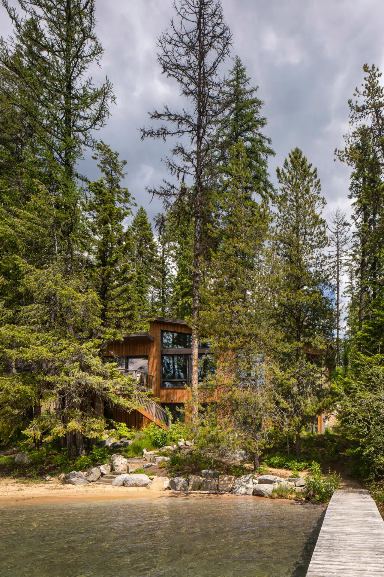 Priest Lake Cabin viewed from the lake. The cabin seems to blend into the surrounding trees.