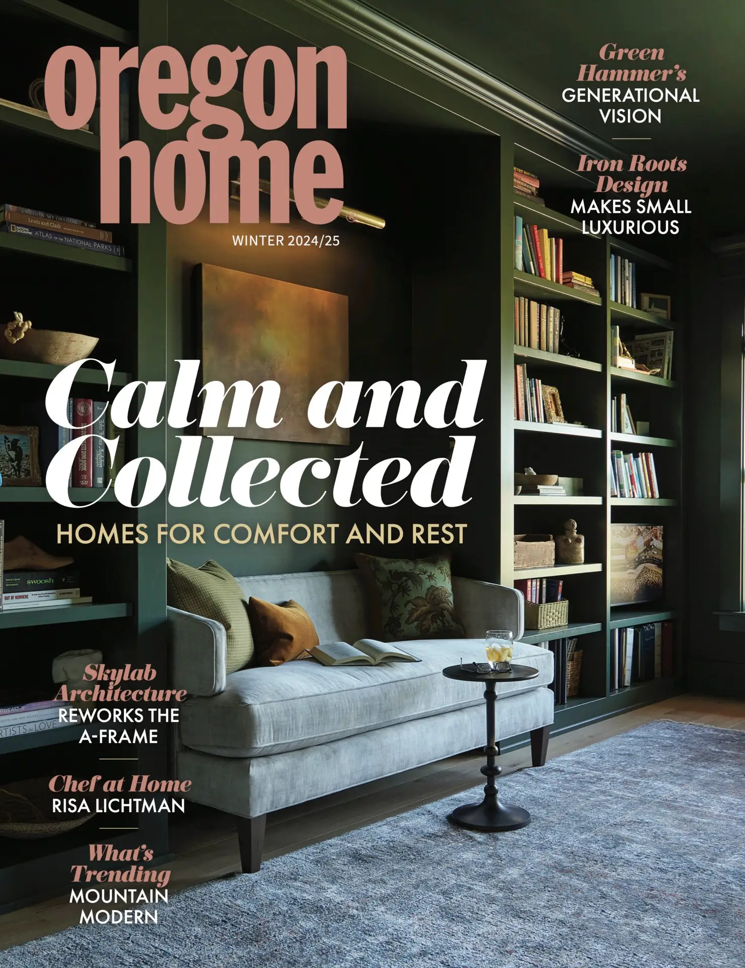 The cover of the Winter 2024/25 issue of Oregon Home magazine, featuring a moody and sophisticated living space designed for "comfort and rest." The walls and built-in bookshelves are painted in a deep, dark forest green, creating a cozy, "moody" atmosphere. A light velvet chaise lounge in a pale grey sits in the foreground, adorned with textured pillows. Beside it is a slim, dark wood pedestal side table holding a glass. Floor-to-ceiling open shelving is filled with a large collection of books and small decorative objects, illuminated by subtle integrated lighting.