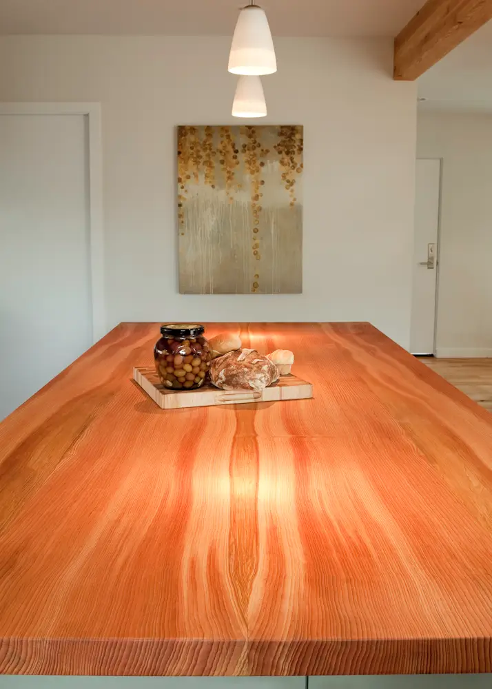 The prominent, handcrafted wood island from the Hale Residence crafted from a thick, edge-grain Pacific Madrone wood slab.