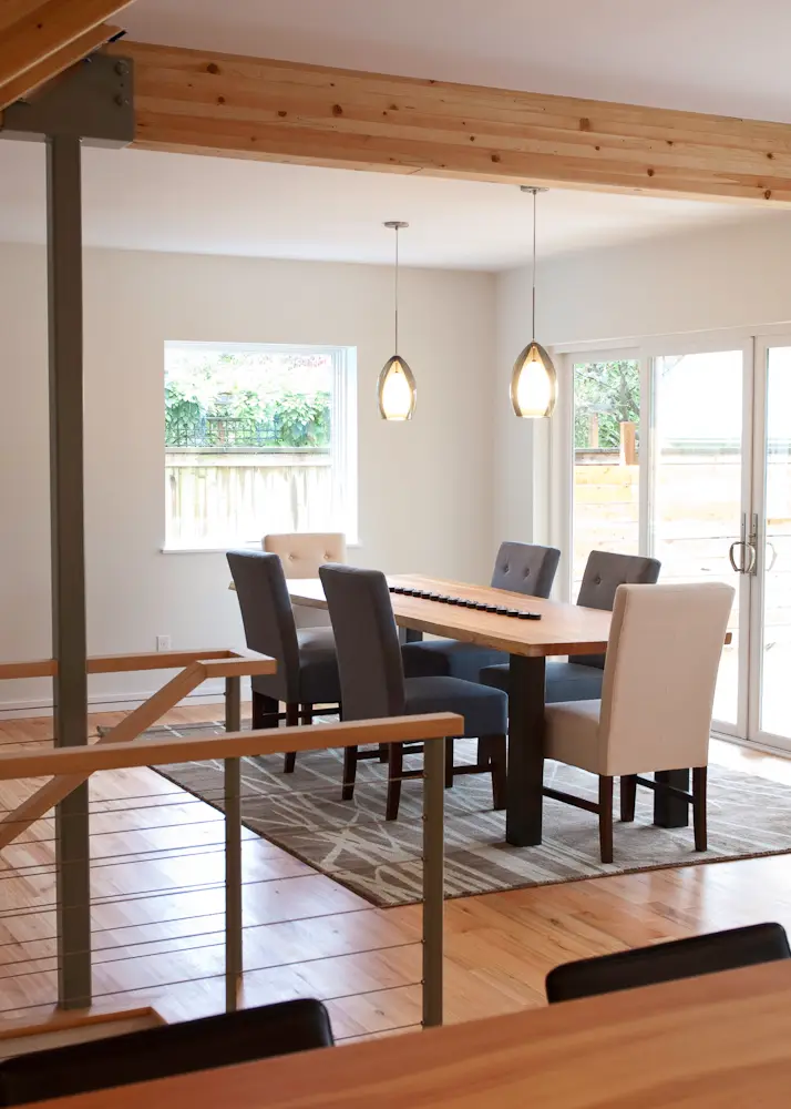 Dining room viewed from the kitchen with an exposed gluelam beam across the ceiling.