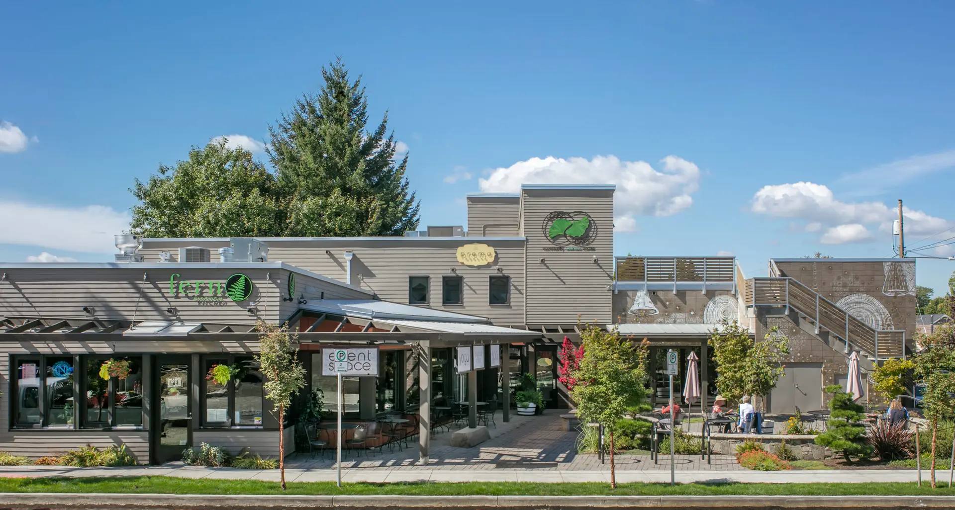 The Breath Building from the street, showing several storefronts and a landscaped courtyard space