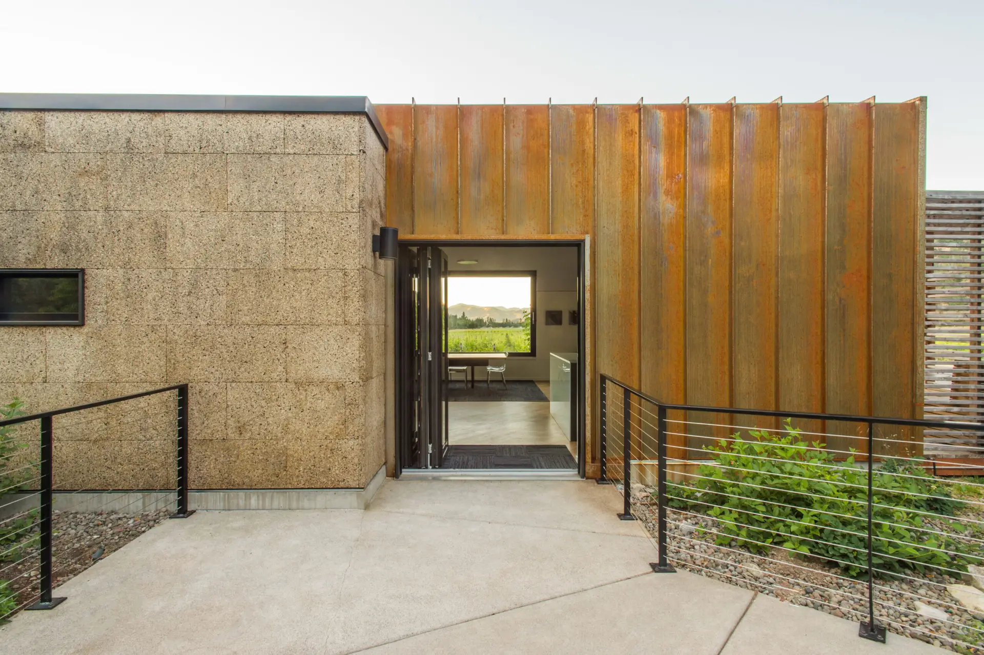 Cowhorn Vineyard and Garden side entrance with cork siding and pre-oxidized and stabilized metal panel siding