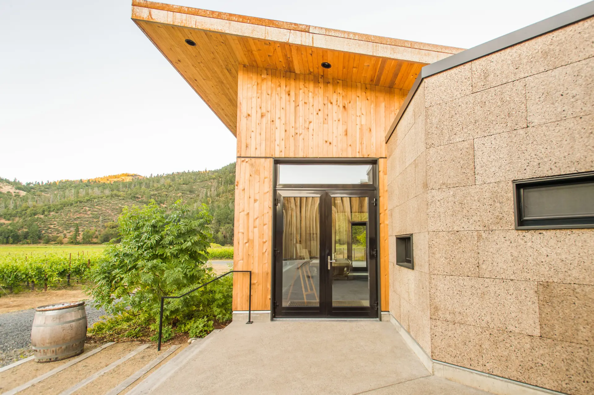 Cowhorn Vineyard and Garden entrance with a full glass double door, cork siding, and wood sizing