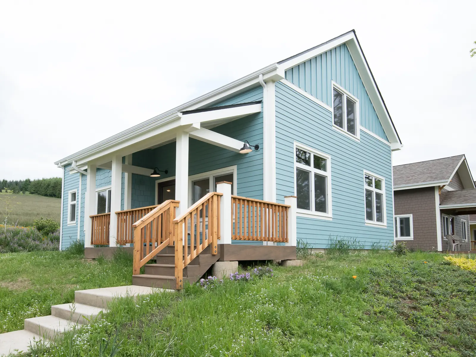Green Grove CoHousing, showing a craftsman style home with blue paint and white trim as well as a front porch with wood railing