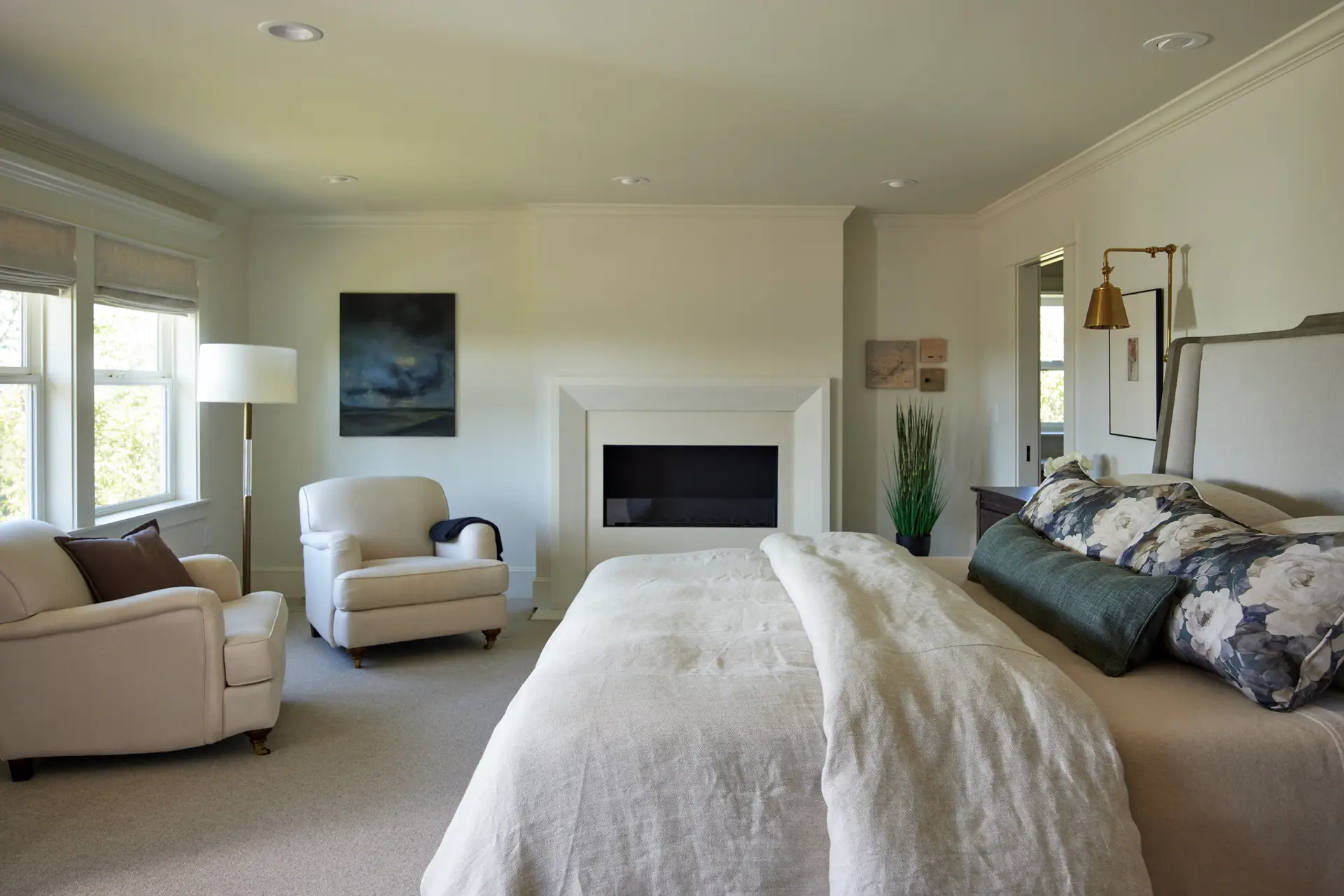 St. Paul Residence primary bedroom, featuring neutral walls and furniture. A fireplace is on the back wall of the room.