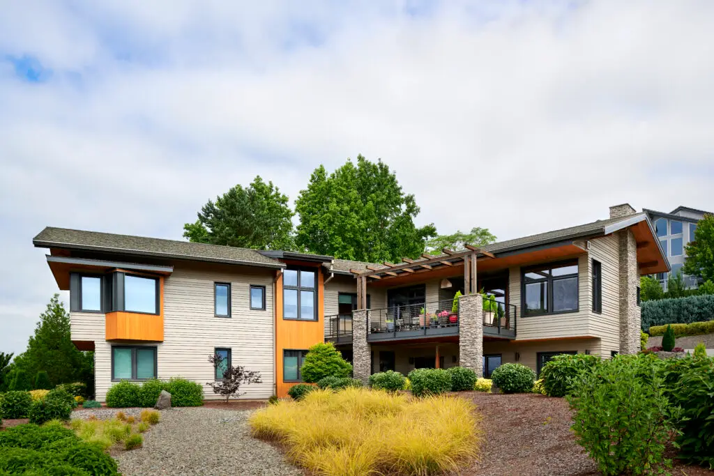 Vancouver Residence view from the street. The home features light grey exterior fiber cement siding combined with a natural wood soffit and thoughtfully placed wood accents around the exterior of the home.