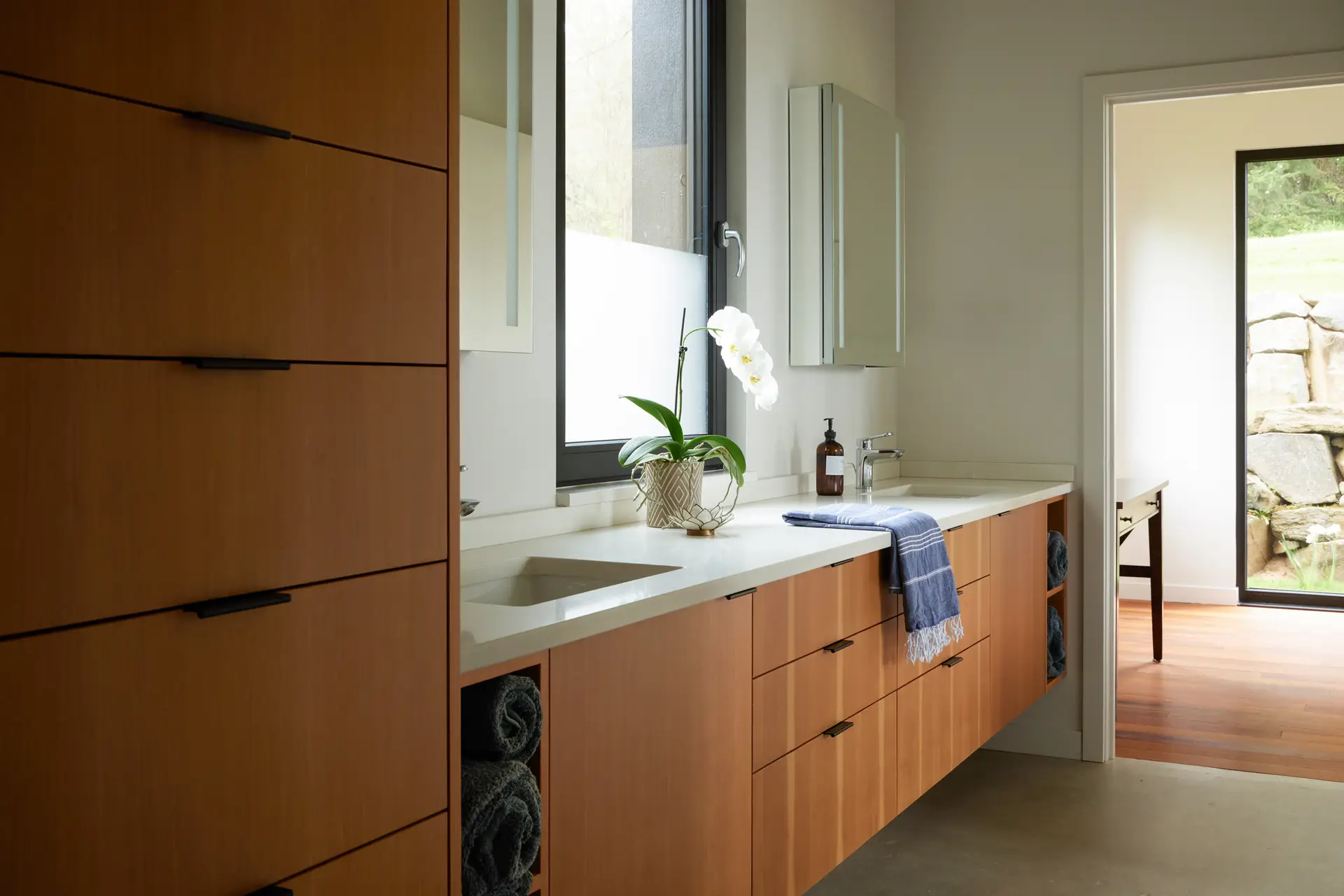 Corbett Residence primary bathroom with a floating white oak vanity and minimalist black finger pulls.