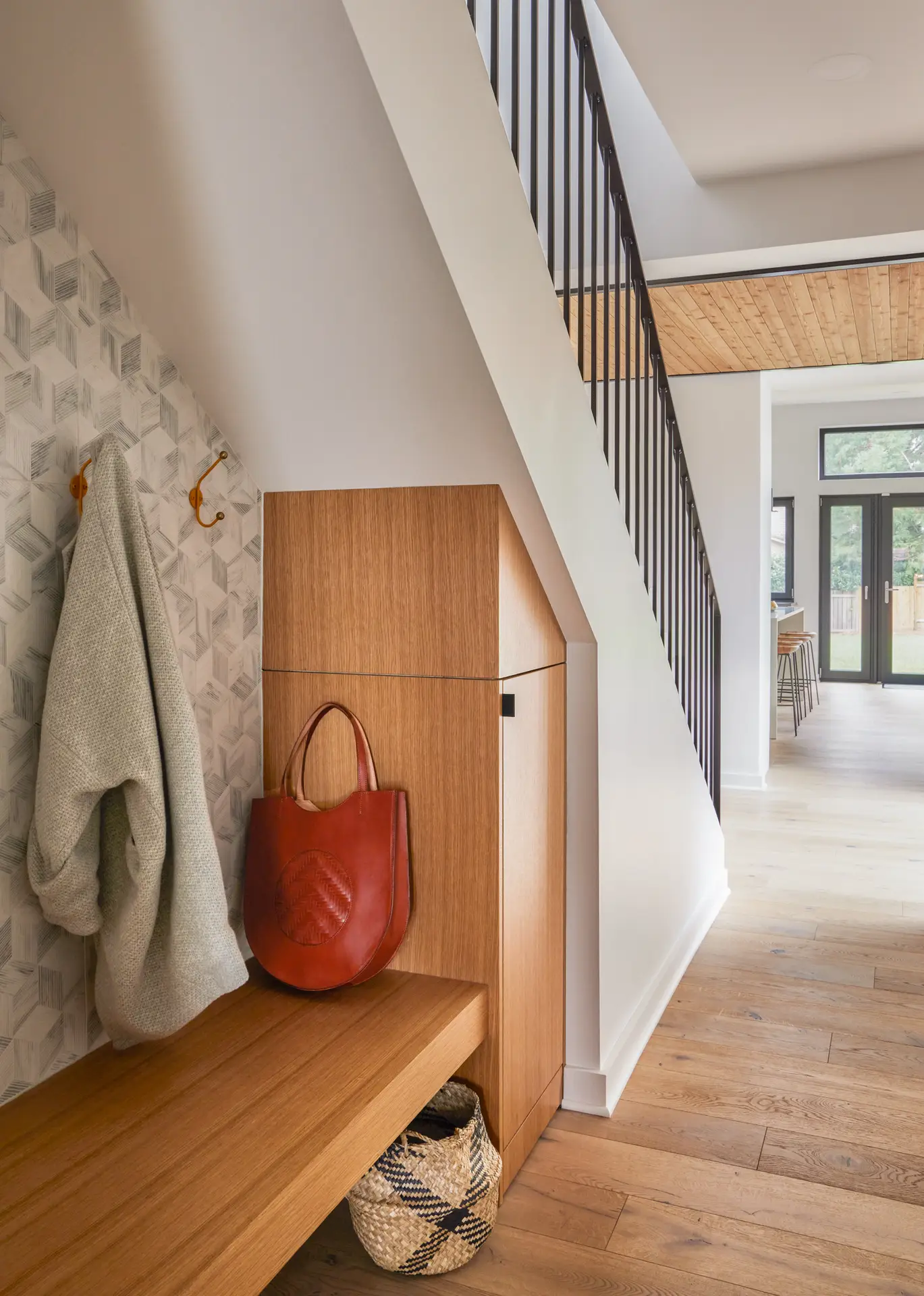 Sunset Residence under stair built in storage with a bench and coat hook