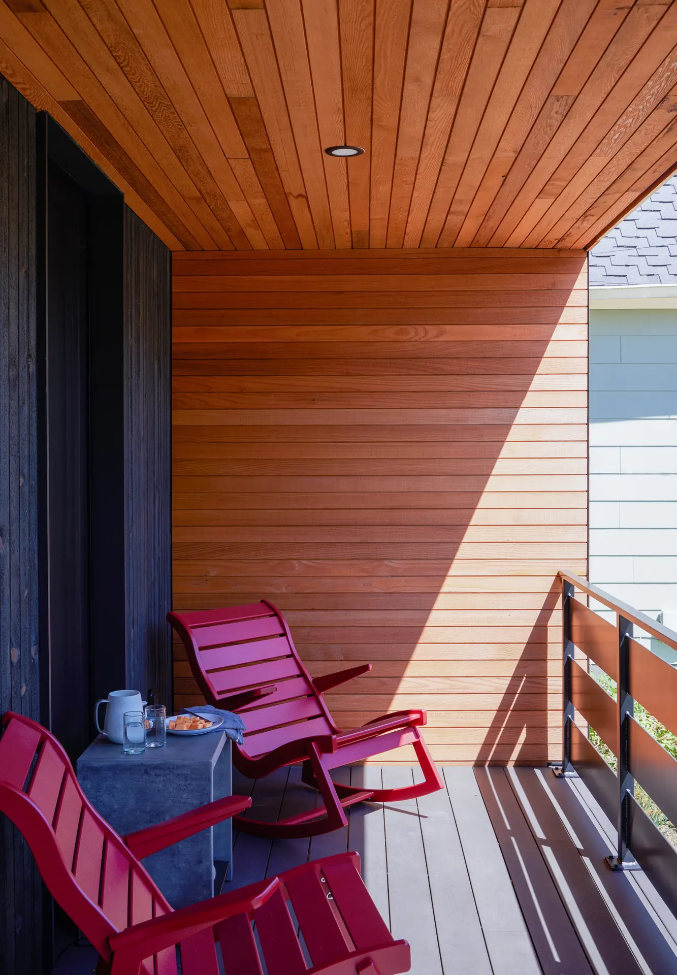 the front patio at Richmond residence, showing 2 patio chairs and a beautiful wood clad wall and ceiling.