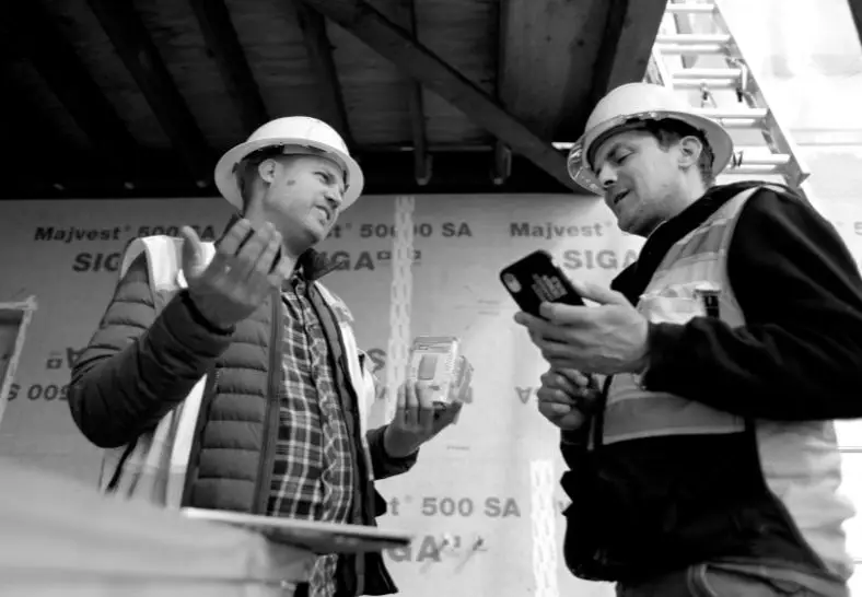Two green hammer team members working out details on the job site.