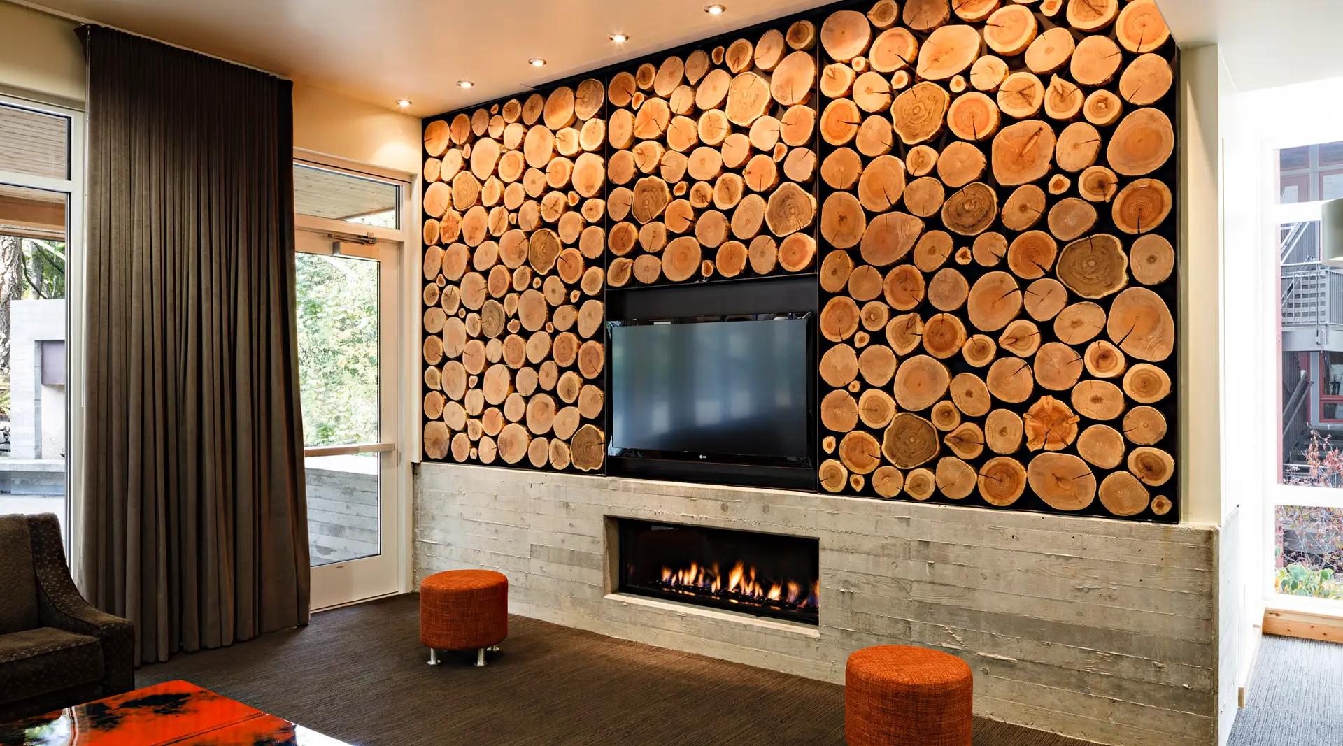 This striking wood-slice feature wall is part of the interior design for the Edna L. Holmes Residence Hall at Lewis & Clark College in Portland, Oregon. The wall was created through a partnership between Green Hammer, Walsh Construction, Mahlum Architects, and Urban Timberworks. The design showcases a commitment to sustainability by reusing approximately 75% of the big-leaf maple and Douglas fir trees that were originally felled on-site during construction. These trees were transformed into functional and decorative elements, including tables, benches, and this unique focal wall.
