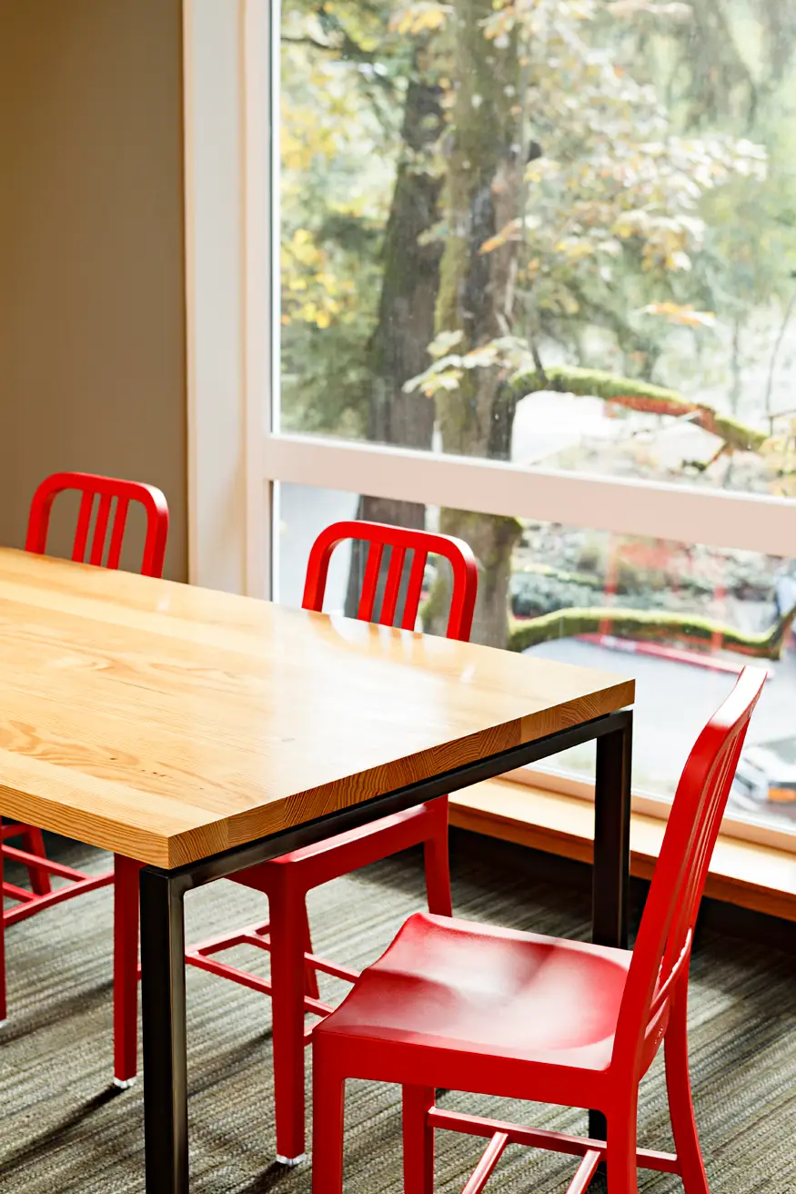 Lewis and Clark college, showing a close in view of a wood table with red chairs