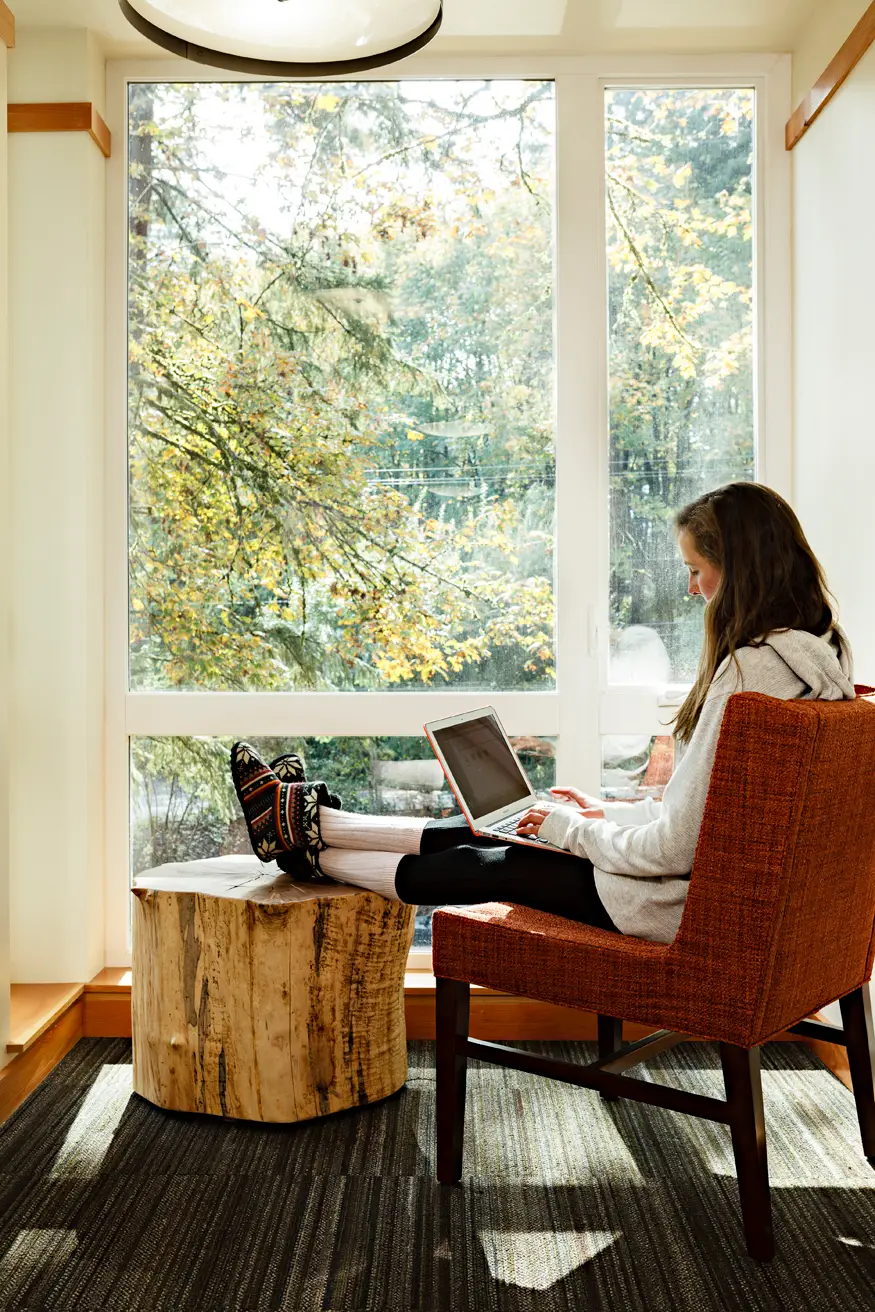 lewis and clark college, showing a woman studying at a chair with her feet upon a log
