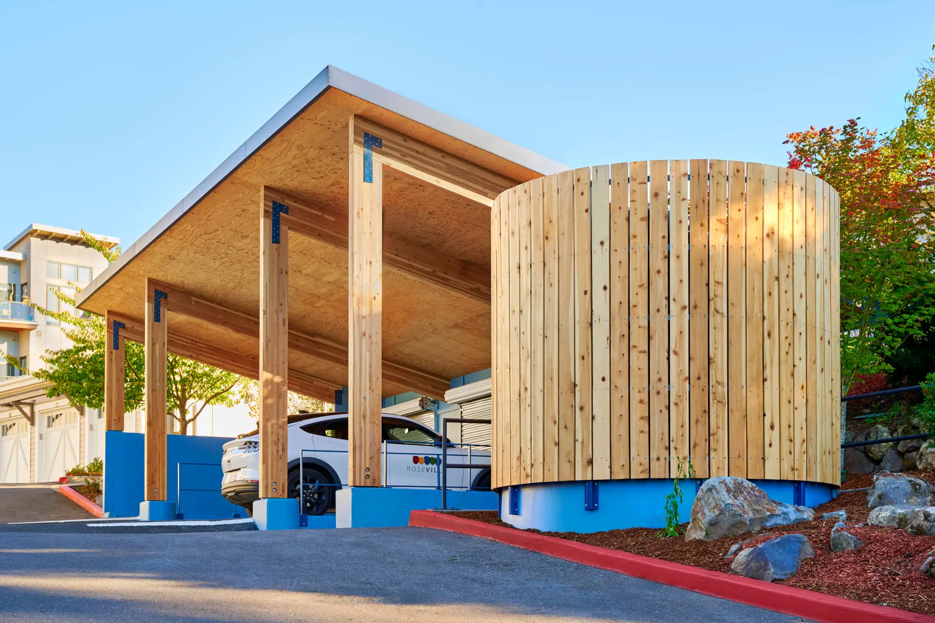 A view looking up the road to the east with a great view of the mass plywood panels from under the roof and the cedar cladding around the rainwater cistern.