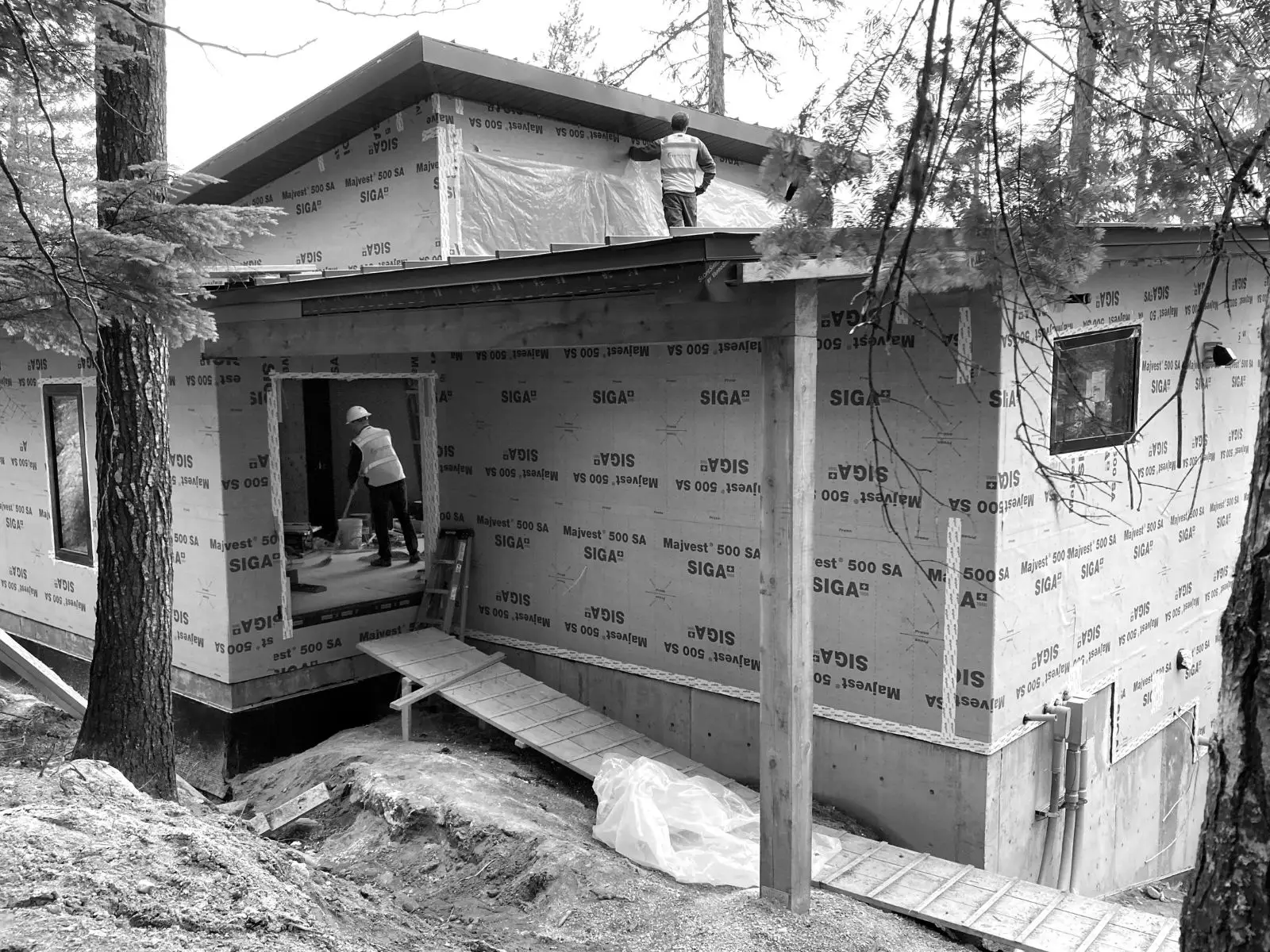 The home under construction with the windows and water resistant barrier stalled. The view is looking inside the home, through the front door.