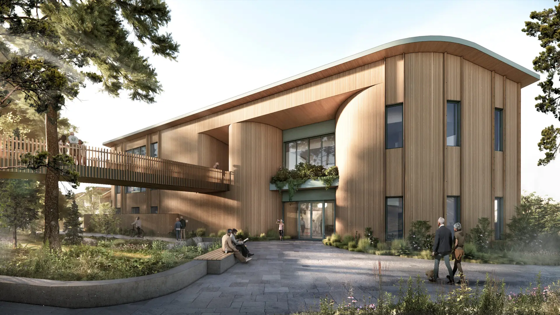 an architectural rendering completed by Side Pixel Studio, showing the entry view of a proposed Wellness center on the campus of Rose Villa Senior Living Community. The design features a two story building with a curved wall entrance as well as a bridge that leads visitors to the 2nd story entrance and is clad with vertical wood siding. The entrance is surrounded by native plants, as designed by Ground Workshop